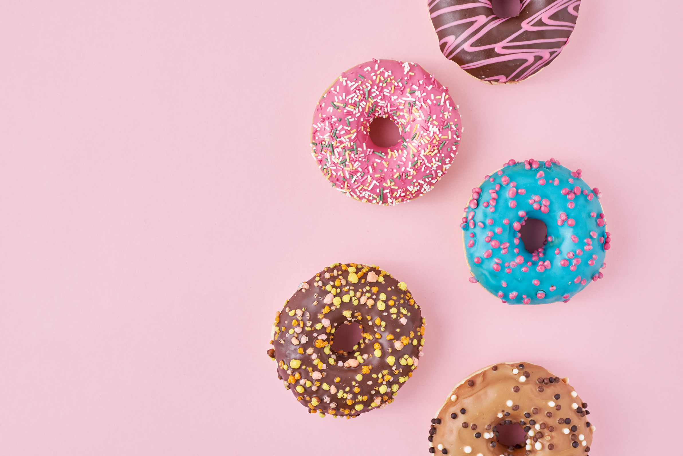 Colorful Assorted Donuts on Pink Background